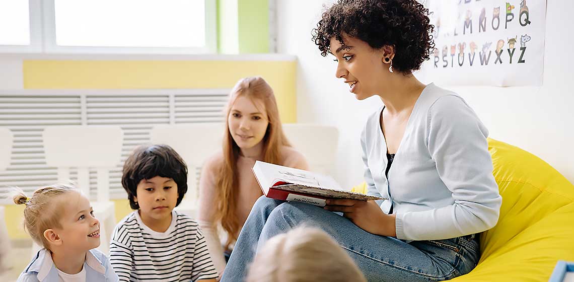 Teacher reading aloud to a group of young children