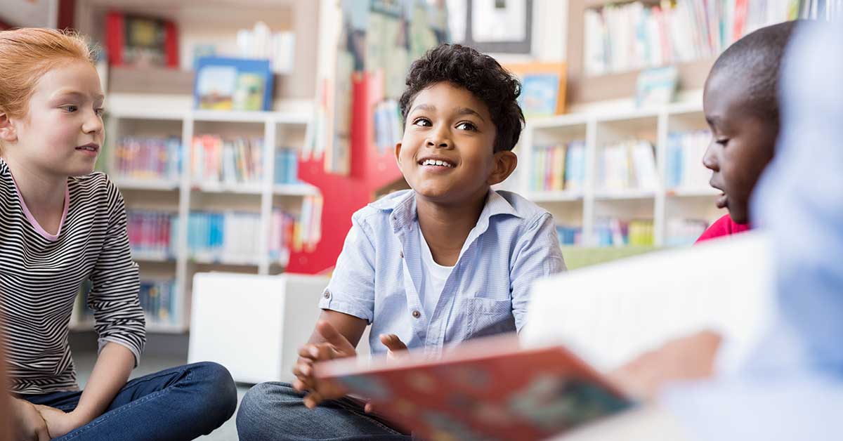 two middle grade students listen as a teacher reads aloud